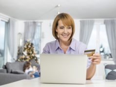 Pożyczka online na Święta – czy to dobry pomysł? Kobieta z kartą przed komputerem