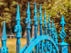 Odpryski i pęknięcia farby na powierzchniach metalowych – dlaczego powstają i jak sobie z nimi radzić? Niebieski metalowy płot