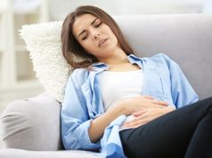 Zapalenie pochwy – jak radzić sobie z tym problemem? Kobieta trzyma ręce na brzuchu
