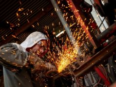 Szlifierka kątowa – jaką wybrać i ile kosztuje? Mężczyzna pracuje szlifierką kątową