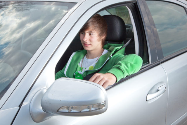 Młody kierowca w srebrnym samochodzie