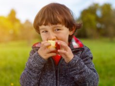 Robaki u dzieci – jak je wykryć, jak się ich pozbyć? Chłopiec je jabłko