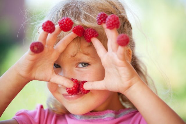 Dziewczynka z owocami na palcach