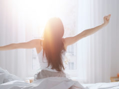 Jak wybrać odpowiedni materac do spania? Wyspana kobieta o poranku