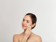 Jakich produktów używać do demakijażu twarzy? Kobieta oczyszczająca twarz mleczkiem do demakijażu