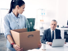 Świadectwo pracy – potrzebne czy nie? kobieta opuszczająca miejsce pracy z kartonem