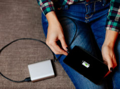 Powerbank – jak wybrać najlepszy? kobieta podpinająca smartfona do powerbanku