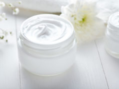 Piękna zimą – porady i kosmetyki krem do twarzy w słoiczku na białym tle