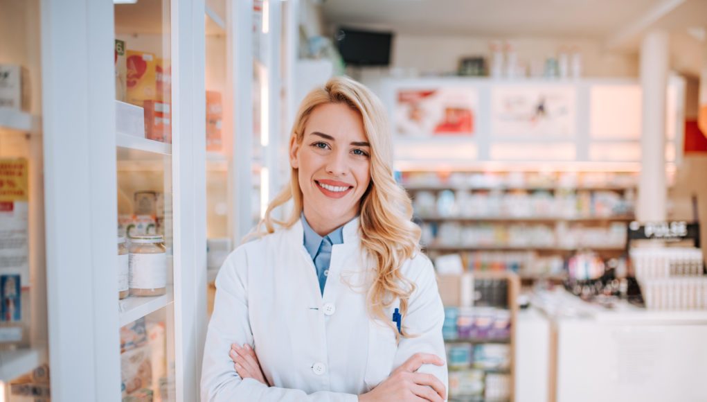 uśmiechnięta farmaceutka na tle apteki