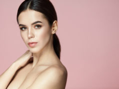 Jakie kuracje kosmetyczne warto wykonywać w okresie zimowym i wczesną wiosną? zadbana szatynka na różowym tle