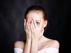 Popularne i zadziwiające fobie – skąd się biorą oraz jak się objawiają? przestraszona kobieta zakrywająca twarz dłońmi