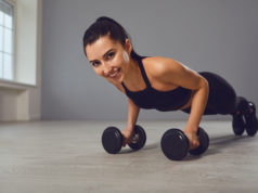 Ćwiczenia w domu, które pomogą schudnąć i wzmocnić mięśnie wysportowana dziewczyna w czerni robiąca pompki na hantlach