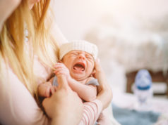 Czy katar u noworodka jest groźny? noworodek płaczący na rękach matki