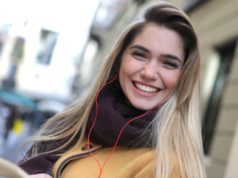 Słuchawki nauszne czy douszne? Podpowiadamy, co wybrać wesoła kobieta w kurtce i szaliku ze słuchawkami przewodowymi w uszach