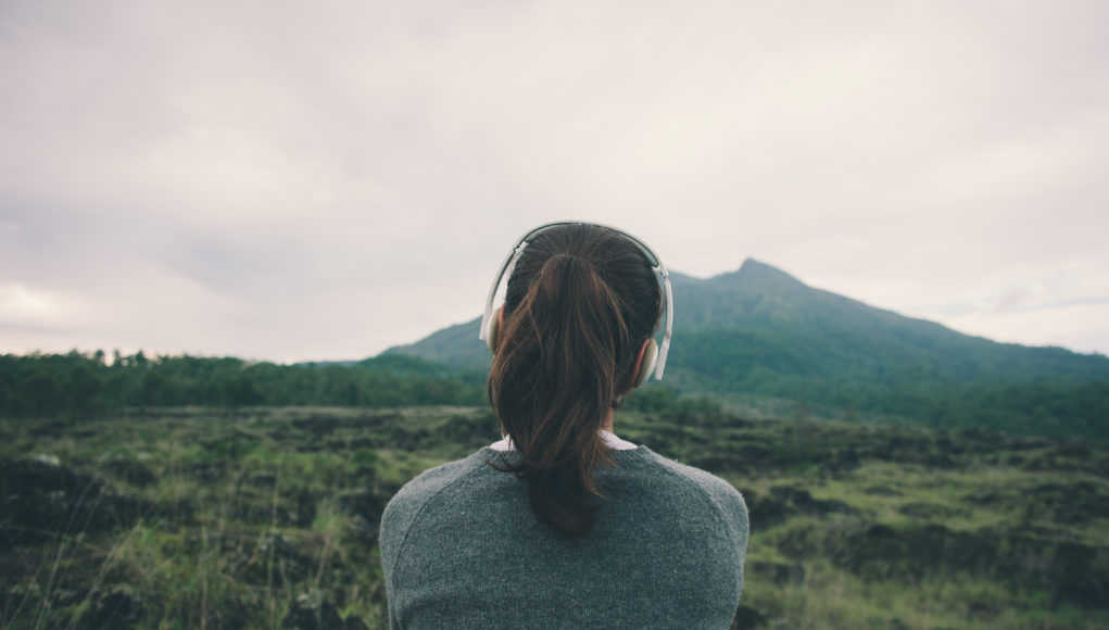 kobieta w górach ze słuchawkami na uszach