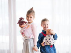 Jaką lalkę wybrać dla dziecka? dwie dziewczynki noszące lalki w nosidełkach