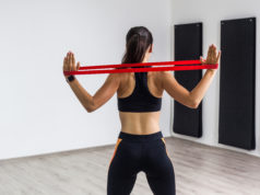 Nie tylko sztangi i hantle, czyli ciekawe, skuteczne i kompaktowe urządzenia oraz akcesoria do ćwiczeń w domu kobieta ćwicząca z gumą