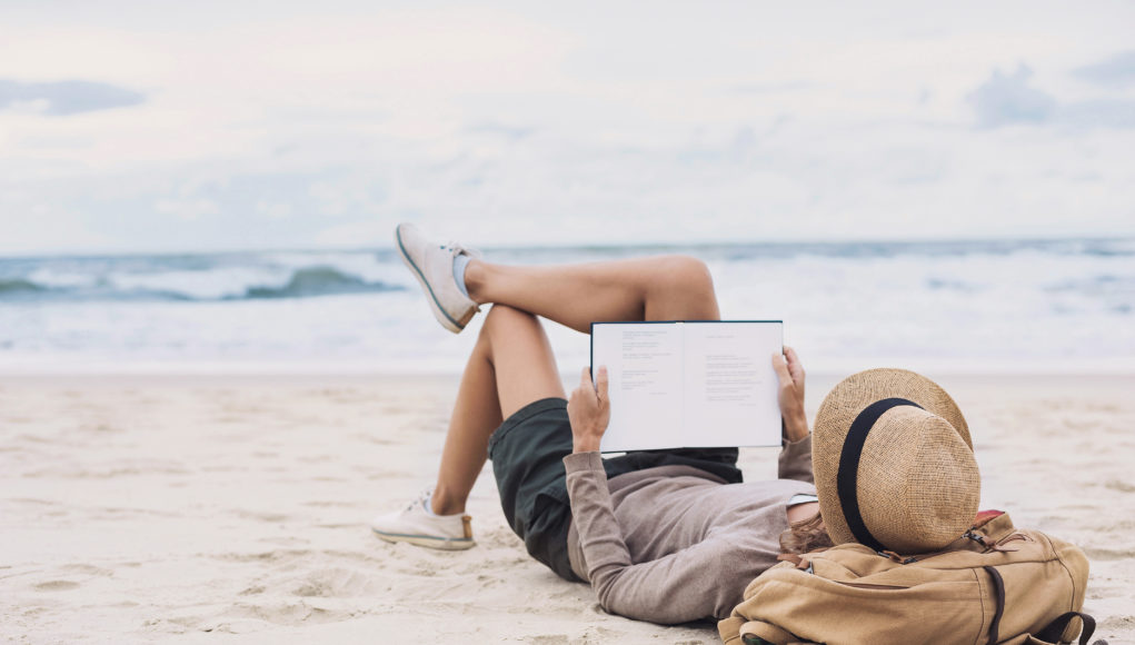 młoda kobieta czytająca na plaży