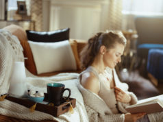 Kilka propozycji znakomitych książek na długie, jesienne wieczory kobieta czytająca książkę w przytulnym domu