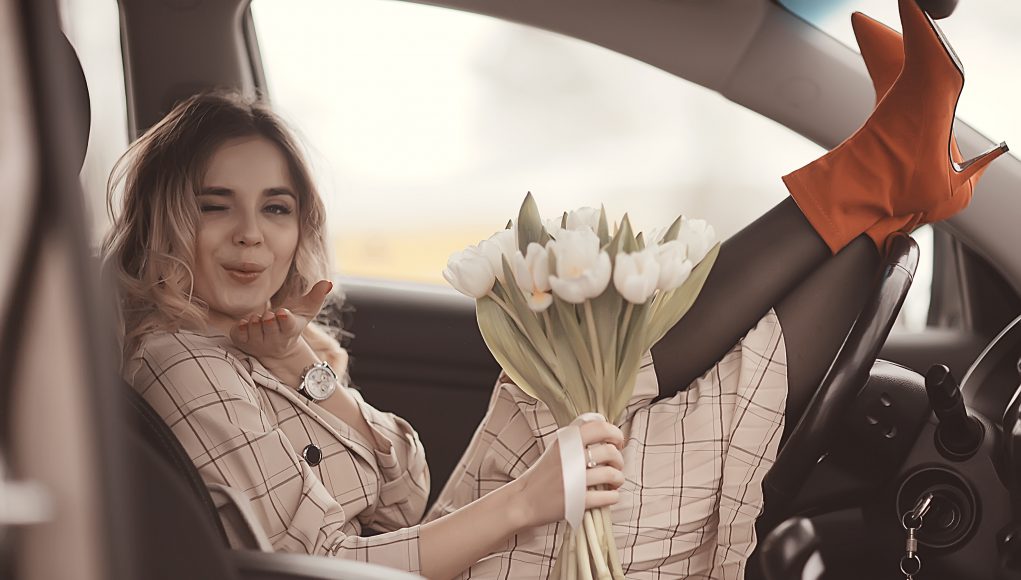 dziewczyna siedząca z kwiatami w samochodzie