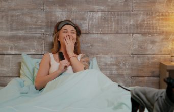 Zmiany w ofercie HBO GO i Netflix – które filmy i seriale warto szybko nadrobić oraz jakie nowości czekają na tych platformach? kobieta oglądająca w łóżku telewizję