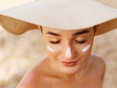 Jak dbać o skórę twarzy latem? piękna kobieta w kapeluszu na plaży